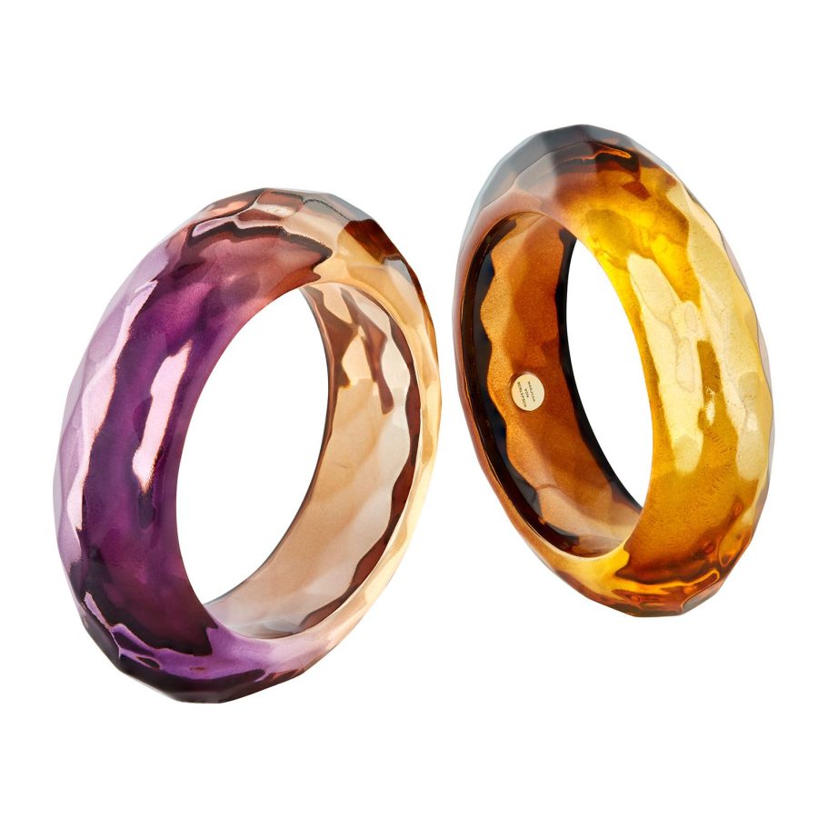 Zwei facettierte Design-Armreifen mit transparentem Farbverlauf in Violett-Rosé und Bernstein-Gold – leuchtende Schmuckfotografie