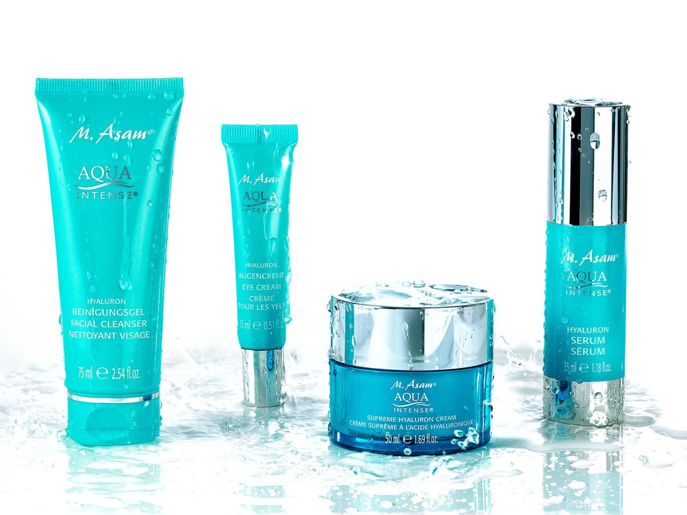 Vier türkisblaue Skincare-Produkte (M. Asam Aqua Intense) mit frischen Wassertropfen auf spritzender Wasseroberfläche – Kosmetik-Werbefoto