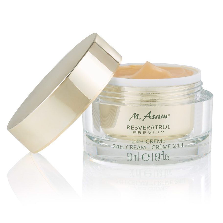 Geöffneter Kosmetik-Glastiegel (M. Asam Resveratrol 24H Creme) mit angelehntem Golddeckel und sichtbarer apricotfarbener Creme-Textur.