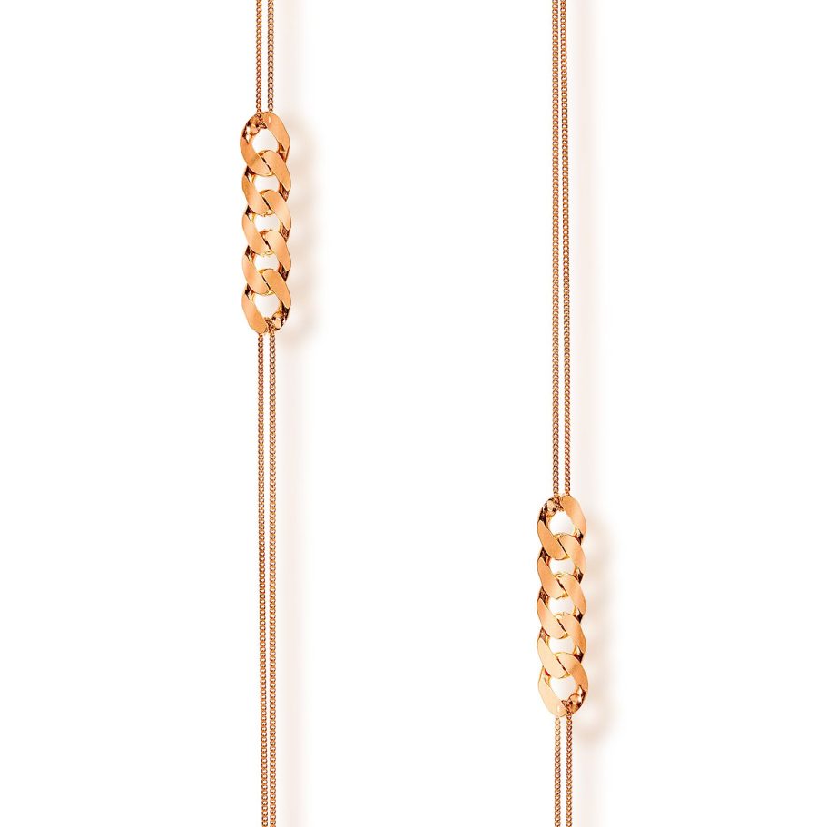 Minimalistische Makroaufnahme einer doppelreihigen Roségold-Kette mit markanten Panzerketten-Gliedern und sanftem Schatten auf Weiß.
